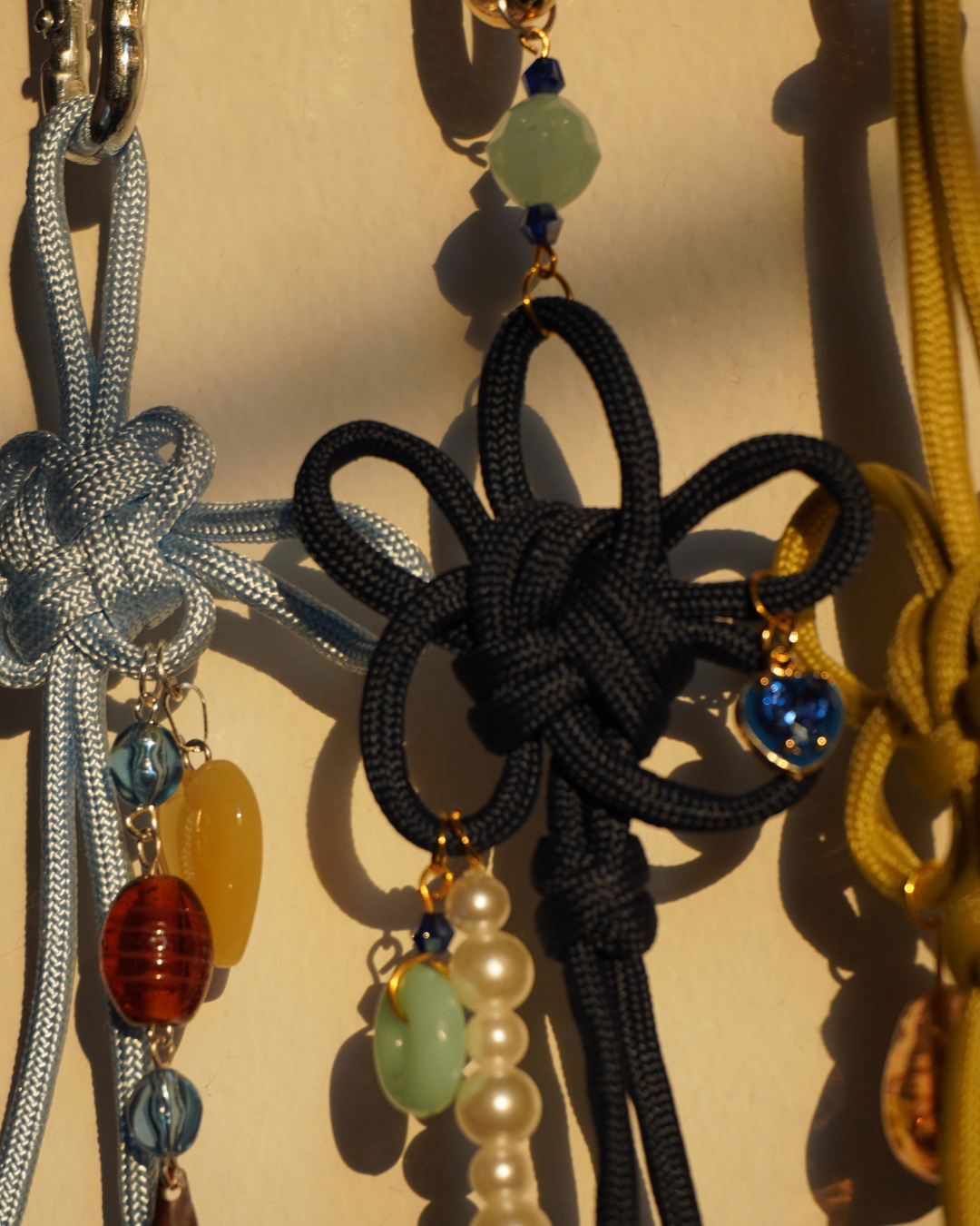 handmade maedeup knot charms with beads on a wood surface